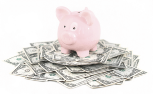 A piggy bank standing on top of cash 
